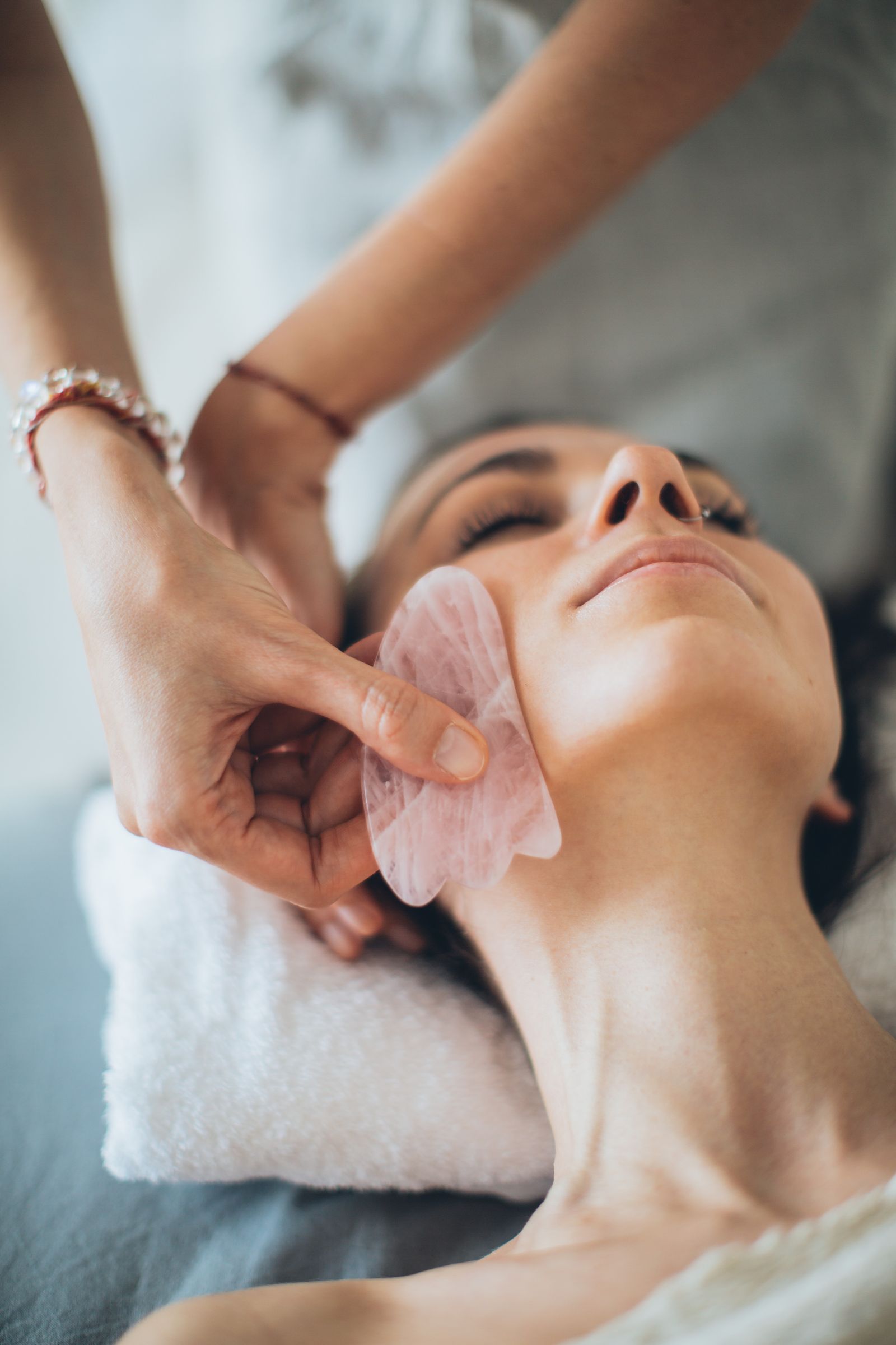 Practitioner performing gua sha massage with a smooth tool